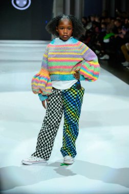 Toronto, ON, Kanada - 7 Aralık 2024: Toronto Çocuk Moda Haftası 'nda IANI koleksiyonunda bir model podyumda yürüyor.