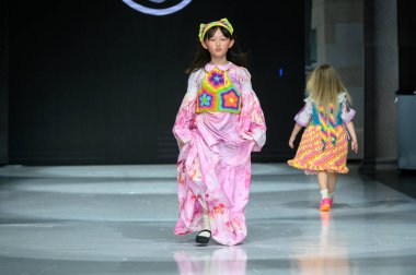 Toronto, ON, Kanada - 7 Aralık 2024: Toronto Çocuk Moda Haftası 'nda IANI koleksiyonunda bir model podyumda yürüyor.