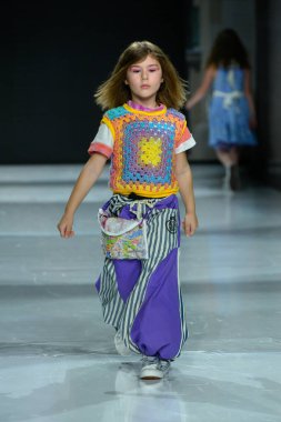 Toronto, ON, Kanada - 7 Aralık 2024: Toronto Çocuk Moda Haftası 'nda IANI koleksiyonunda bir model podyumda yürüyor.