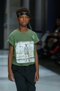 Toronto, ON, Kanada - 7 Aralık 2024: Toronto Çocuk Moda Haftası 'nda Onix Gold koleksiyonunda bir model podyumda yürüyor.