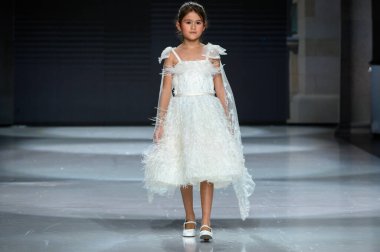 Toronto, ON, Kanada - 7 Aralık 2024: Toronto Çocuk Moda Haftası Moda Şovu sırasında Milana Loren Couture koleksiyonunda bir model podyumda yürüyor.