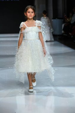 Toronto, ON, Kanada - 7 Aralık 2024: Toronto Çocuk Moda Haftası Moda Şovu sırasında Milana Loren Couture koleksiyonunda bir model podyumda yürüyor.