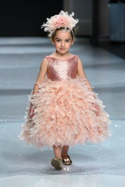 Toronto, ON, Kanada - 7 Aralık 2024: Toronto Çocuk Moda Haftası Moda Şovu sırasında Milana Loren Couture koleksiyonunda bir model podyumda yürüyor.