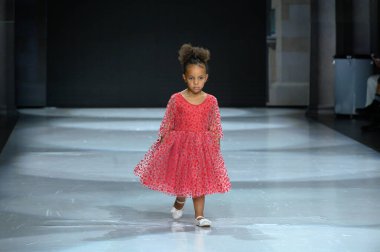 Toronto, ON, Kanada - 7 Aralık 2024: Toronto Çocuk Moda Haftası Moda Şovu sırasında Milana Loren Couture koleksiyonunda bir model podyumda yürüyor.