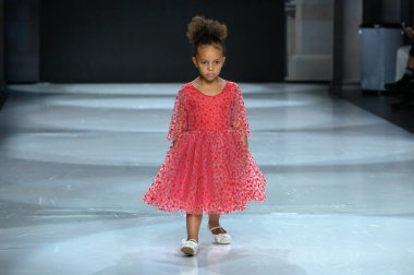 Toronto, ON, Kanada - 7 Aralık 2024: Toronto Çocuk Moda Haftası Moda Şovu sırasında Milana Loren Couture koleksiyonunda bir model podyumda yürüyor.