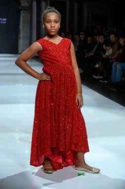 Toronto, ON, Kanada - 7 Aralık 2024: Toronto Çocuk Moda Haftası Moda Şovu sırasında Milana Loren Couture koleksiyonunda bir model podyumda yürüyor.