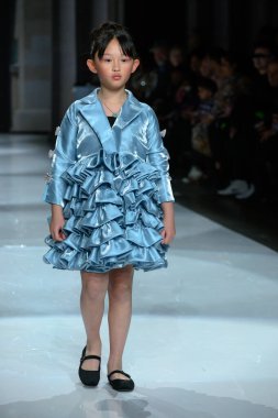 Toronto, ON, Kanada - 7 Aralık 2024: Toronto Çocuk Moda Haftası Moda Şovu sırasında Milana Loren Couture koleksiyonunda bir model podyumda yürüyor.