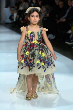 Toronto, ON, Kanada - 7 Aralık 2024: Toronto Çocuk Moda Haftası Moda Şovu sırasında Milana Loren Couture koleksiyonunda bir model podyumda yürüyor.