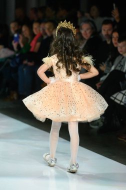 Toronto, ON, Kanada - 7 Aralık 2024: Toronto Çocuk Moda Haftası defilesi sırasında Hawa Moda Dünyası koleksiyonunda bir model podyumda yürüyor.