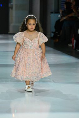 Toronto, ON, Kanada - 7 Aralık 2024: Toronto Çocuk Moda Haftası defilesi sırasında Hawa Moda Dünyası koleksiyonunda bir model podyumda yürüyor.