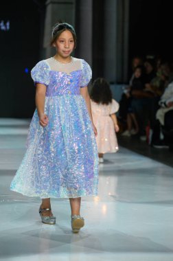 Toronto, ON, Kanada - 7 Aralık 2024: Toronto Çocuk Moda Haftası defilesi sırasında Hawa Moda Dünyası koleksiyonunda bir model podyumda yürüyor.