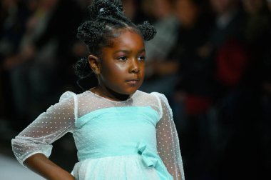 Toronto, ON, Kanada - 7 Aralık 2024: Toronto Çocuk Moda Haftası defilesi sırasında Hawa Moda Dünyası koleksiyonunda bir model podyumda yürüyor.