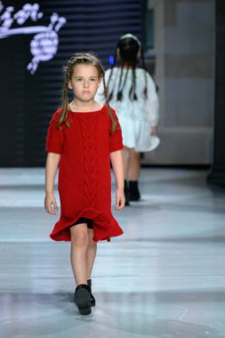 Toronto, ON, Kanada - 7 Aralık 2024: Toronto Çocuk Moda Haftası defilesinde Sneglisa koleksiyonunda bir model podyumda yürüyor.