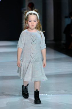 Toronto, ON, Kanada - 7 Aralık 2024: Toronto Çocuk Moda Haftası defilesinde Sneglisa koleksiyonunda bir model podyumda yürüyor.