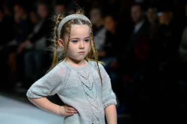 Toronto, ON, Kanada - 7 Aralık 2024: Toronto Çocuk Moda Haftası defilesinde Sneglisa koleksiyonunda bir model podyumda yürüyor.