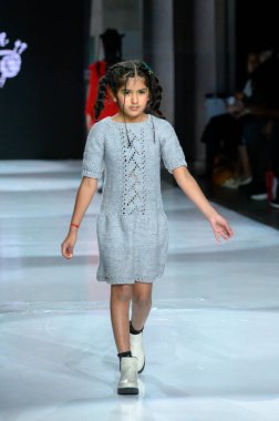 Toronto, ON, Kanada - 7 Aralık 2024: Toronto Çocuk Moda Haftası defilesinde Sneglisa koleksiyonunda bir model podyumda yürüyor.