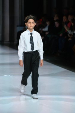 Toronto, ON, Kanada - 7 Aralık 2024: Toronto Çocuk Moda Şovu sırasında Zero20Kids koleksiyonunda bir model podyumda yürüyor.