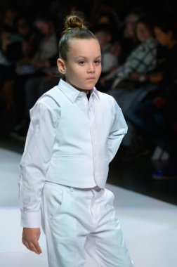 Toronto, ON, Kanada - 7 Aralık 2024: Toronto Çocuk Moda Şovu sırasında Zero20Kids koleksiyonunda bir model podyumda yürüyor.