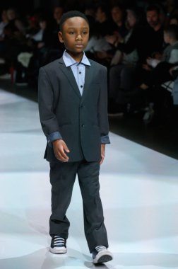 Toronto, ON, Kanada - 7 Aralık 2024: Toronto Çocuk Moda Şovu sırasında Zero20Kids koleksiyonunda bir model podyumda yürüyor.
