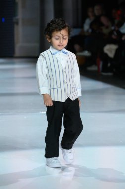 Toronto, ON, Kanada - 7 Aralık 2024: Toronto Çocuk Moda Şovu sırasında Zero20Kids koleksiyonunda bir model podyumda yürüyor.