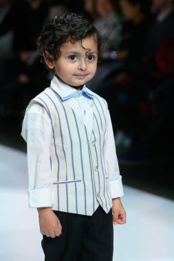 Toronto, ON, Kanada - 7 Aralık 2024: Toronto Çocuk Moda Şovu sırasında Zero20Kids koleksiyonunda bir model podyumda yürüyor.