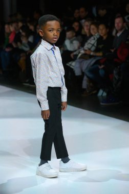 Toronto, ON, Kanada - 7 Aralık 2024: Toronto Çocuk Moda Şovu sırasında Zero20Kids koleksiyonunda bir model podyumda yürüyor.