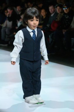 Toronto, ON, Kanada - 7 Aralık 2024: Toronto Çocuk Moda Şovu sırasında Zero20Kids koleksiyonunda bir model podyumda yürüyor.