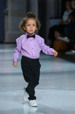 Toronto, ON, Kanada - 7 Aralık 2024: Toronto Çocuk Moda Şovu sırasında Zero20Kids koleksiyonunda bir model podyumda yürüyor.