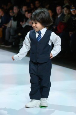 Toronto, ON, Kanada - 7 Aralık 2024: Toronto Çocuk Moda Şovu sırasında Zero20Kids koleksiyonunda bir model podyumda yürüyor.