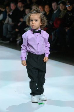 Toronto, ON, Kanada - 7 Aralık 2024: Toronto Çocuk Moda Şovu sırasında Zero20Kids koleksiyonunda bir model podyumda yürüyor.