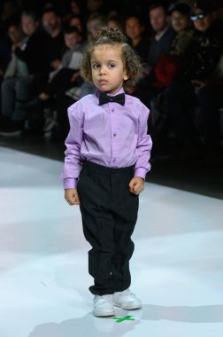 Toronto, ON, Kanada - 7 Aralık 2024: Toronto Çocuk Moda Şovu sırasında Zero20Kids koleksiyonunda bir model podyumda yürüyor.