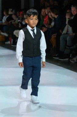 Toronto, ON, Kanada - 7 Aralık 2024: Toronto Çocuk Moda Şovu sırasında Zero20Kids koleksiyonunda bir model podyumda yürüyor.