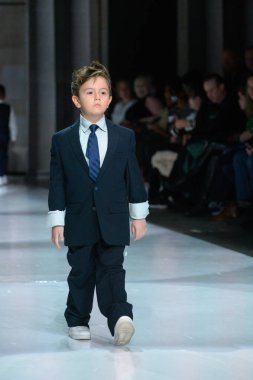 Toronto, ON, Kanada - 7 Aralık 2024: Toronto Çocuk Moda Şovu sırasında Zero20Kids koleksiyonunda bir model podyumda yürüyor.