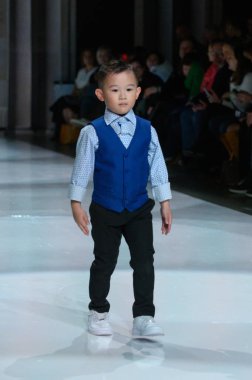 Toronto, ON, Kanada - 7 Aralık 2024: Toronto Çocuk Moda Şovu sırasında Zero20Kids koleksiyonunda bir model podyumda yürüyor.