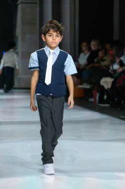 Toronto, ON, Kanada - 7 Aralık 2024: Toronto Çocuk Moda Şovu sırasında Zero20Kids koleksiyonunda bir model podyumda yürüyor.