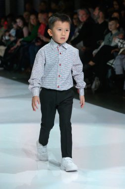 Toronto, ON, Kanada - 7 Aralık 2024: Toronto Çocuk Moda Şovu sırasında Zero20Kids koleksiyonunda bir model podyumda yürüyor.
