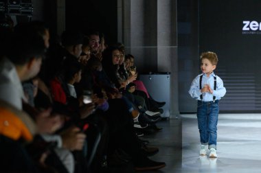 Toronto, ON, Kanada - 7 Aralık 2024: Toronto Çocuk Moda Şovu sırasında Zero20Kids koleksiyonunda bir model podyumda yürüyor.