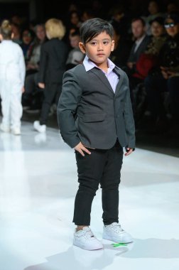 Toronto, ON, Kanada - 7 Aralık 2024: Toronto Çocuk Moda Şovu sırasında Zero20Kids koleksiyonunda bir model podyumda yürüyor.