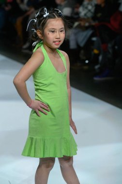 Toronto, ON, Kanada - 7 Aralık 2024: Toronto Çocuk Moda Haftası 'nda Little Olin koleksiyonunda bir model podyumda yürüyor.