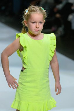 Toronto, ON, Canada - December 7, 2024: A model walks the runway at the Little Olin collection during the Toronto Kids Fashion Week fashion show. clipart