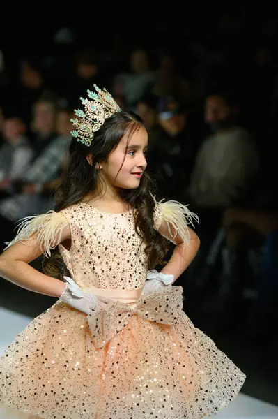 Toronto, ON, Kanada - 7 Aralık 2024: Toronto Çocuk Moda Haftası defilesi sırasında Hawa Moda Dünyası koleksiyonunda bir model podyumda yürüyor.