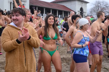 Toronto, ON, Canada  January 1, 2025: People are about to dive into Lake Ontario's cold water (+3)  during the annual Polar Bear Dip on New Year's Day at Sunnyside Beach.. clipart