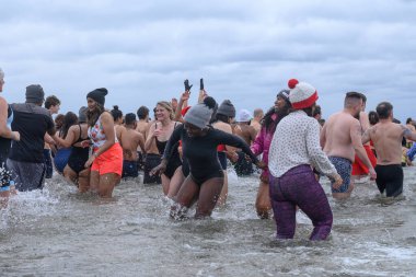 Toronto, ON, Kanada 1 Ocak 2025: Toronto Kutup Ayısı Dalışı sırasında Sunnyside Sahili 'ndeki Ontario Gölü' nün soğuk sularına (+ 3) akın eden insanlar..