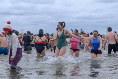Toronto, ON, Kanada 1 Ocak 2025: Toronto Kutup Ayısı Dalışı sırasında Sunnyside Sahili 'ndeki Ontario Gölü' nün soğuk sularında (+ 3C) insanlar görülüyor.