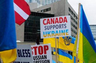 Toronto, ON, Kanada 23 Şubat 2025: Göstericiler, Rusya 'nın Ukrayna' yı tam ölçekli işgalinin 3. yıldönümünde Nathan Phillips Meydanı 'nda düzenlenen gösterinin bayrağını taşıyor..