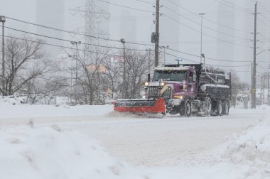 Toronto, ON, Kanada - 27 Şubat 2025: Kar küreme aracı kar fırtınası sırasında yolu temizliyor.