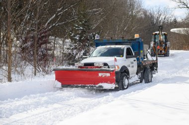 Toronto, ON, Kanada - 27 Şubat 2025: Bir kar küreme aracı ve tuz kamyonu kışın karlı bir yolu temizler, kar taşır ve buzlu yüzeyde güvenliği artırmak için tuz yayar.