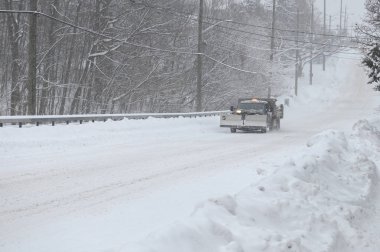 Toronto, ON, Kanada - 27 Şubat 2025: Kar temizleme kovalı bir araç karlı bir yolda ilerliyor