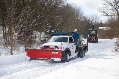 Toronto, ON, Kanada - 27 Şubat 2025: Bir kar küreme aracı ve tuz kamyonu kışın karlı bir yolu temizler, kar taşır ve buzlu yüzeyde güvenliği artırmak için tuz yayar.