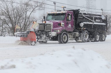 Toronto, ON, Kanada - 27 Şubat 2025: Kar küreme aracı kar fırtınası sırasında yolu temizliyor.
